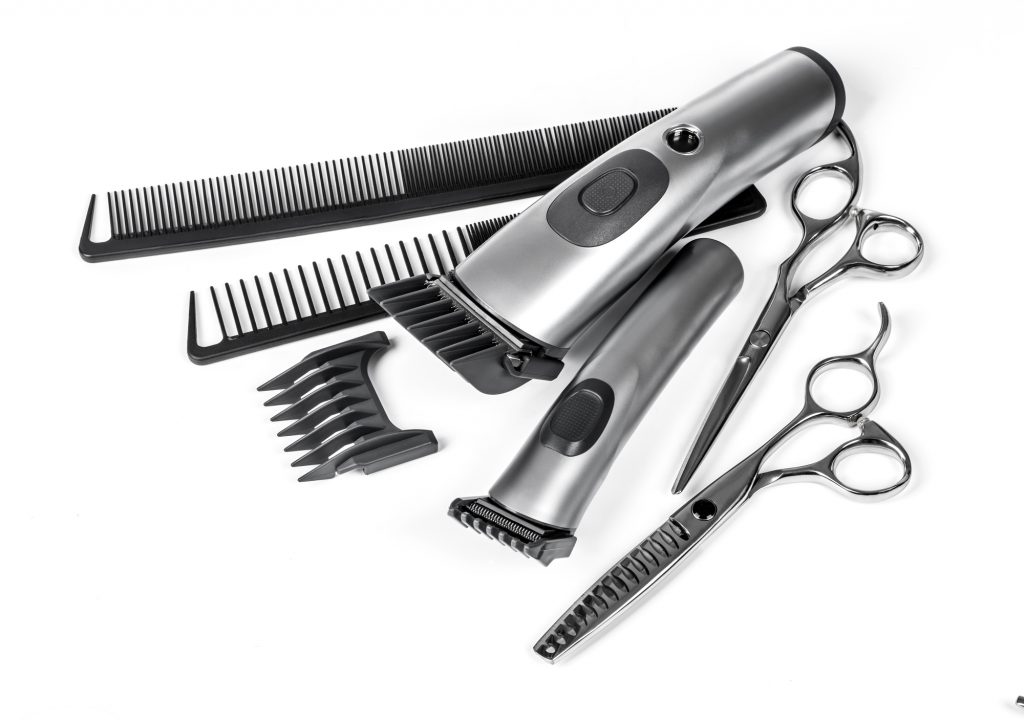 hair clipper, comb and scissors on white background