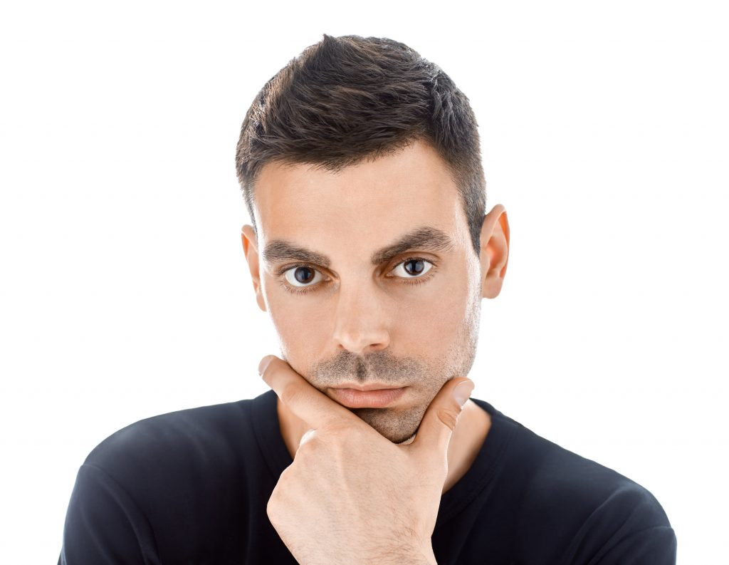 Portrait of young handsome man touching his chin isolated on white background